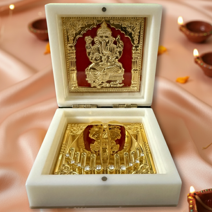 Decorative box with gold Ganesh statue on a soft pink background