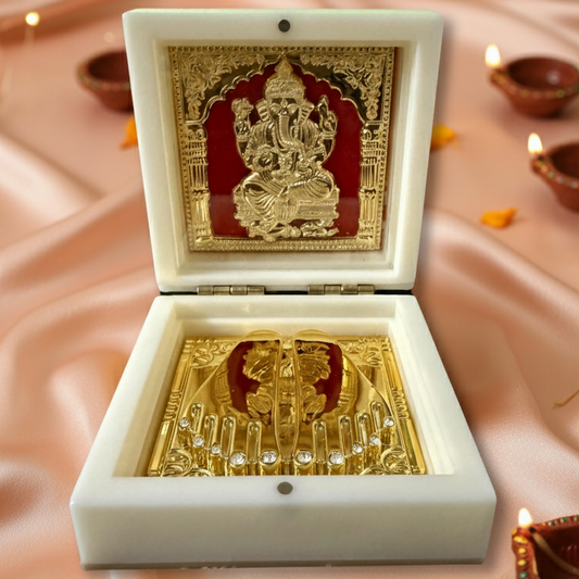 Decorative box with gold Ganesh statue on a soft pink background